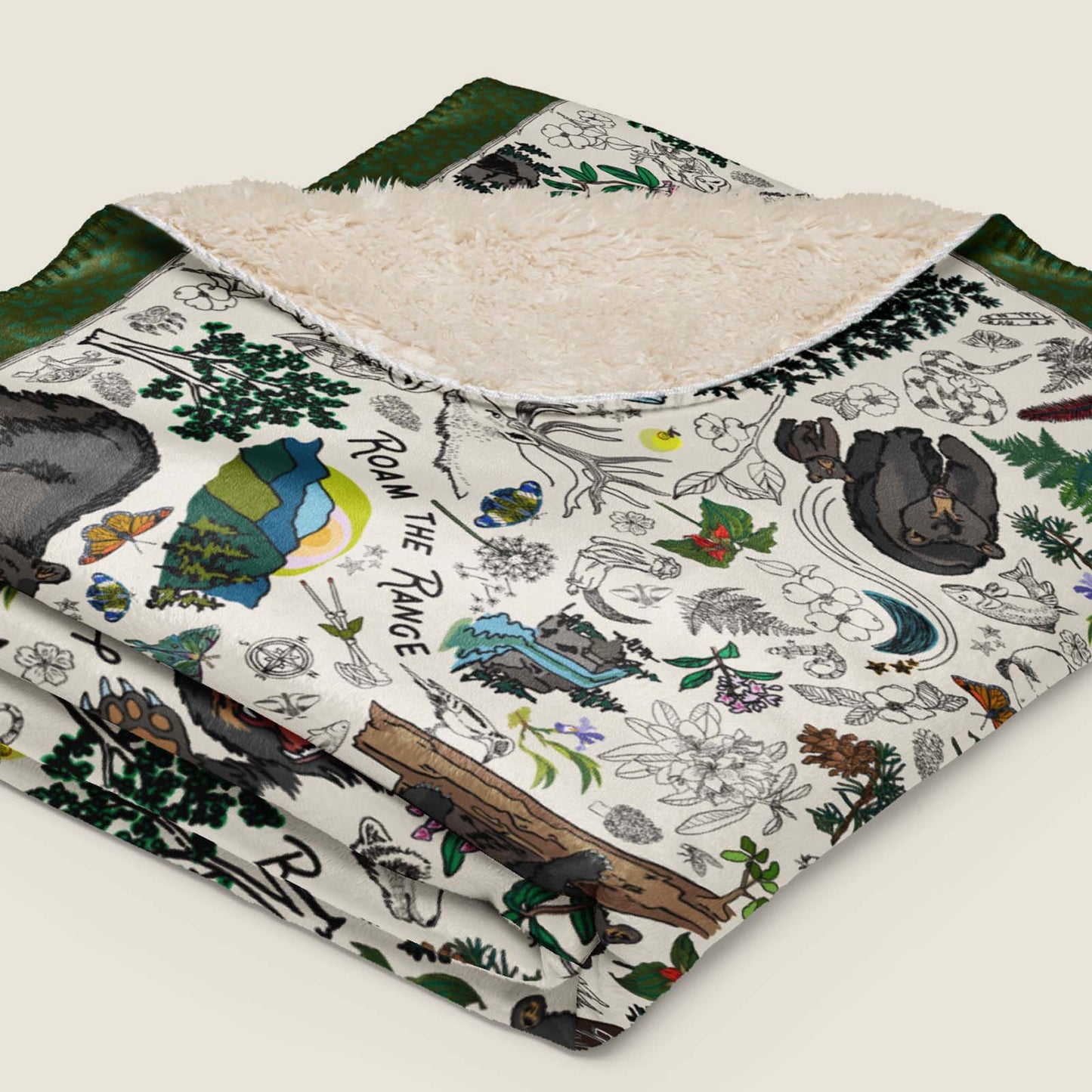 Mountain Adventures Faux Fur Sherpa blanket folded and lying on an ivory background.
