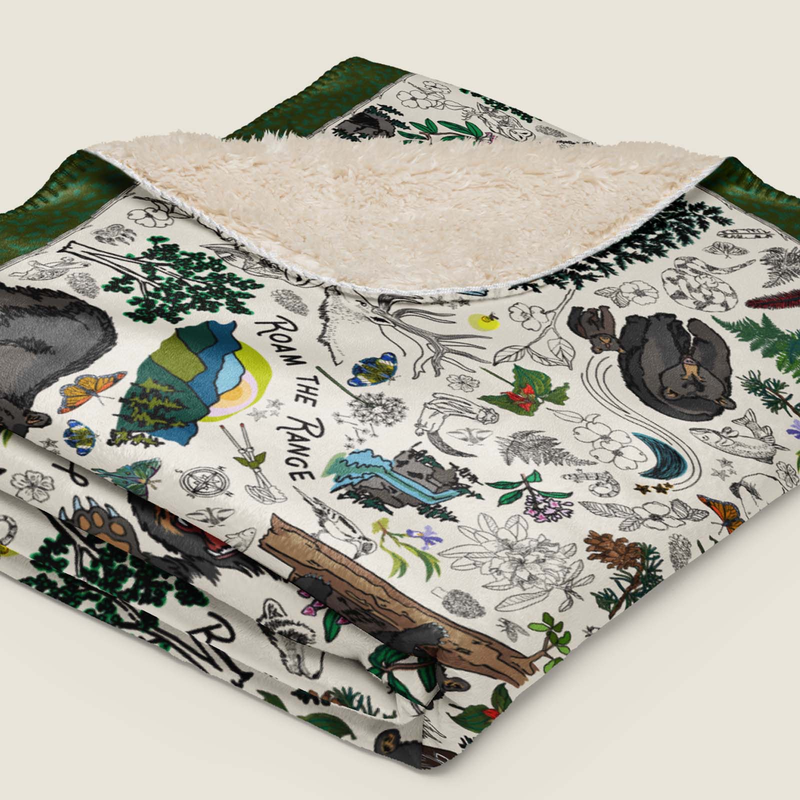 Mountain Adventures Faux Fur Sherpa blanket folded and lying on an ivory background.
