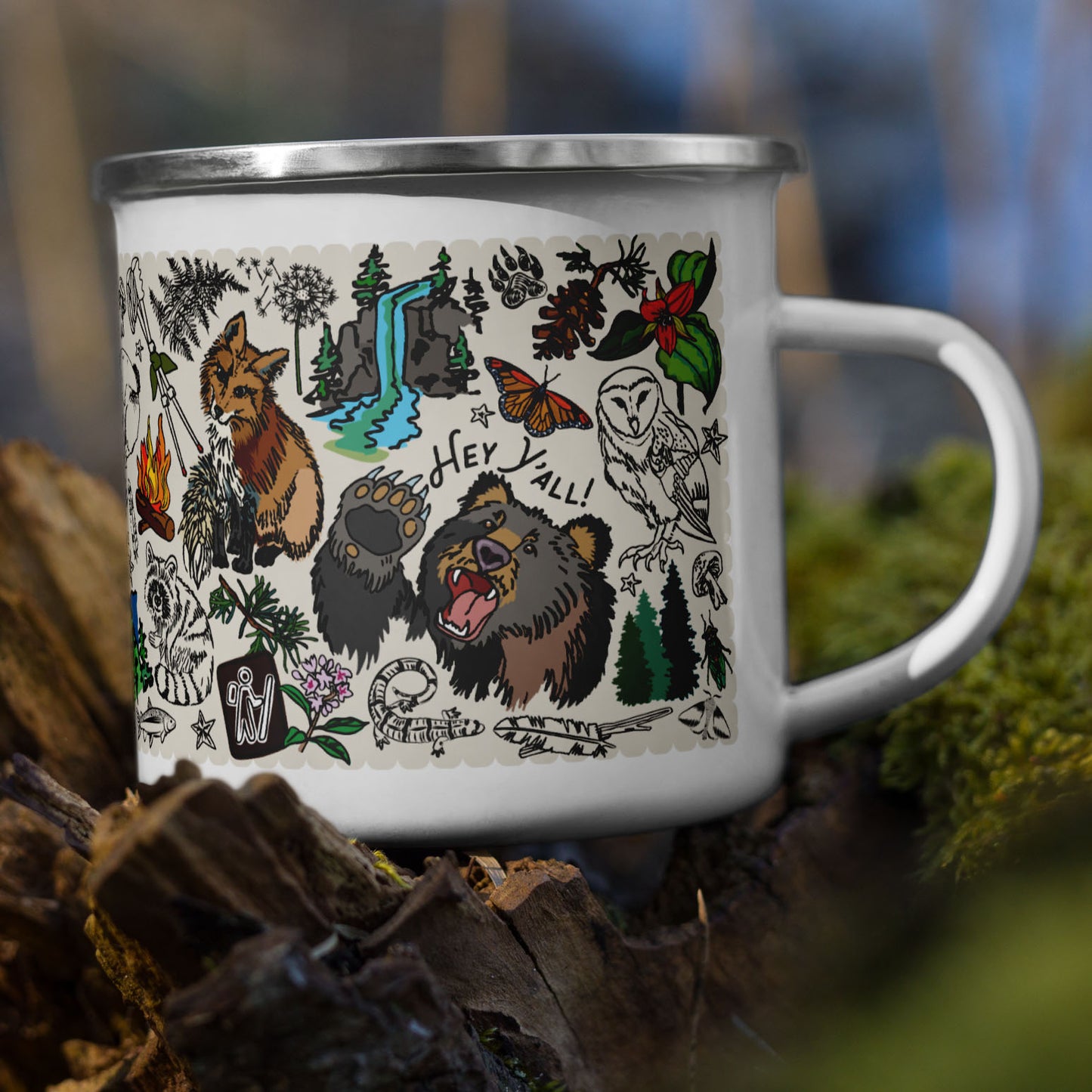 The Mountain Hikes camp mug nestled in a tree stump with moss.