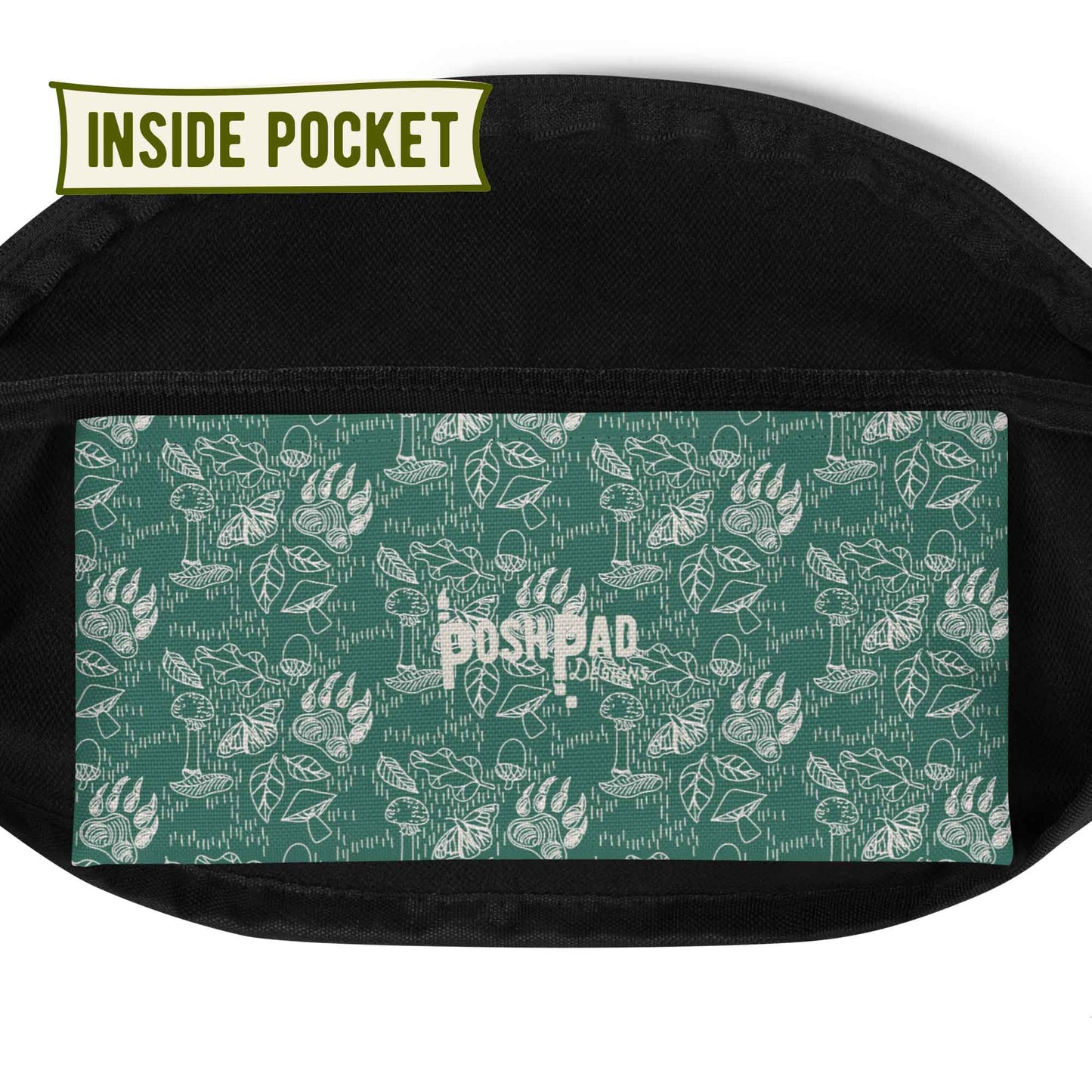 View of the inside pocket. It has a white pattern of bear paws, mushrooms, butterflies, and leaves on a green background. The Posh Pad logo is in the middle.