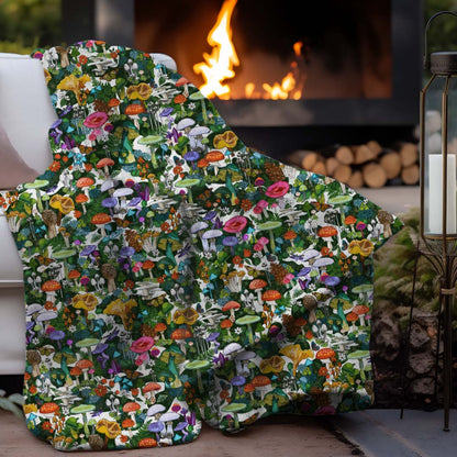 Wild Mushroom sherpa blanket draped over a couch by a fire pit in an outdoor setting.