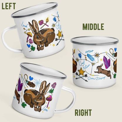 This image shows all sides of the camp mug so you can see how the artwork wraps around. The middle illustrations is the Orion constellation, stars, crystals, feathers, and leaping rabbit. Both sides have a lucky bunny. The left side has a lucky star with crossing arrows to symbolize loyalty. There are hearts, lucky four-leaf clovers, intermingled with inspirational sayings like "Divine Blessings", "Good Fortune", "Love", and "Luck".