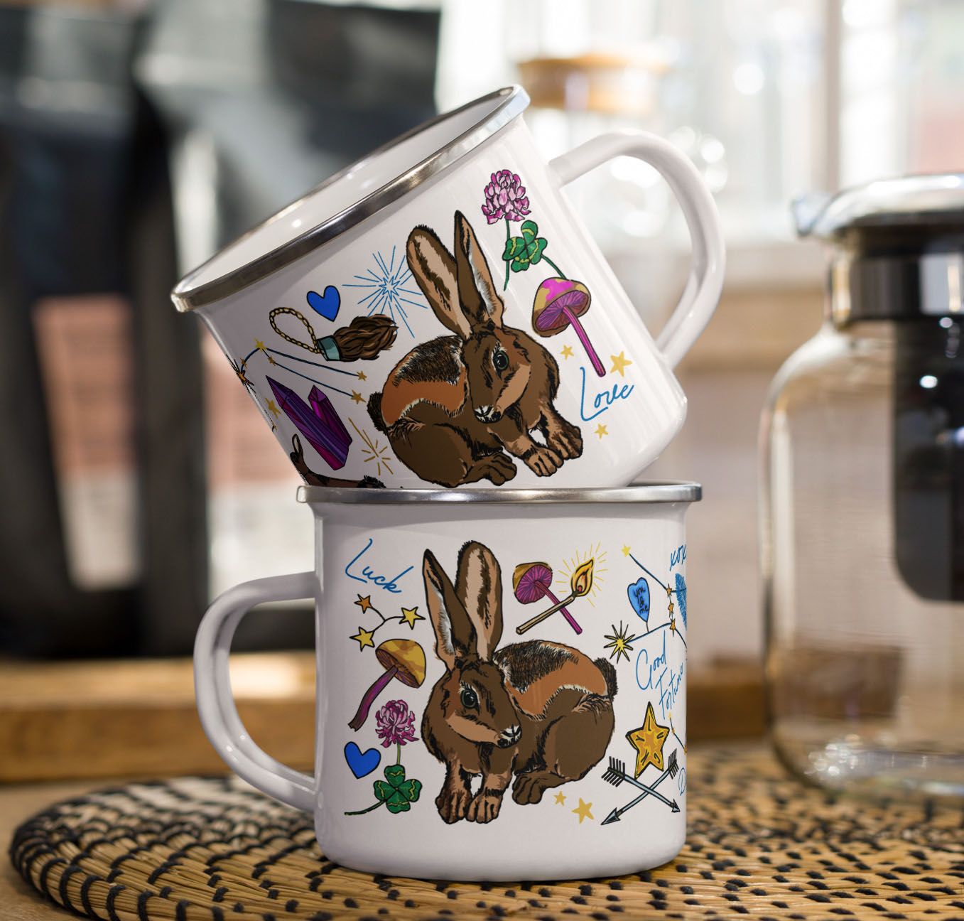 This is a photo of the Orion Stars enamel coffee mugs stacked on a kitchen counter sitting beside a coffee pot and bags of coffee.