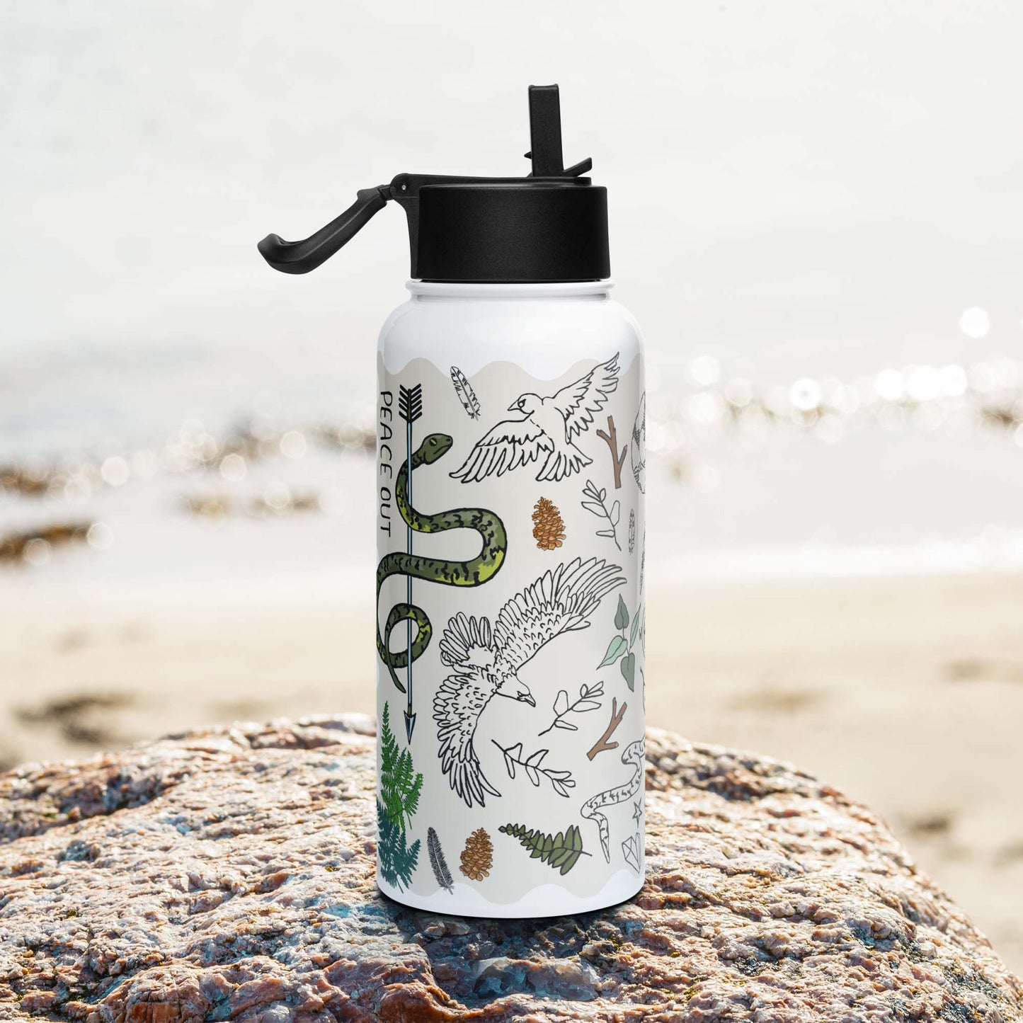 Photo showing the right side of the Peace Out in the Woods Insulated Water Bottle with Straw Lid as it sits on a rock beside  a lake.