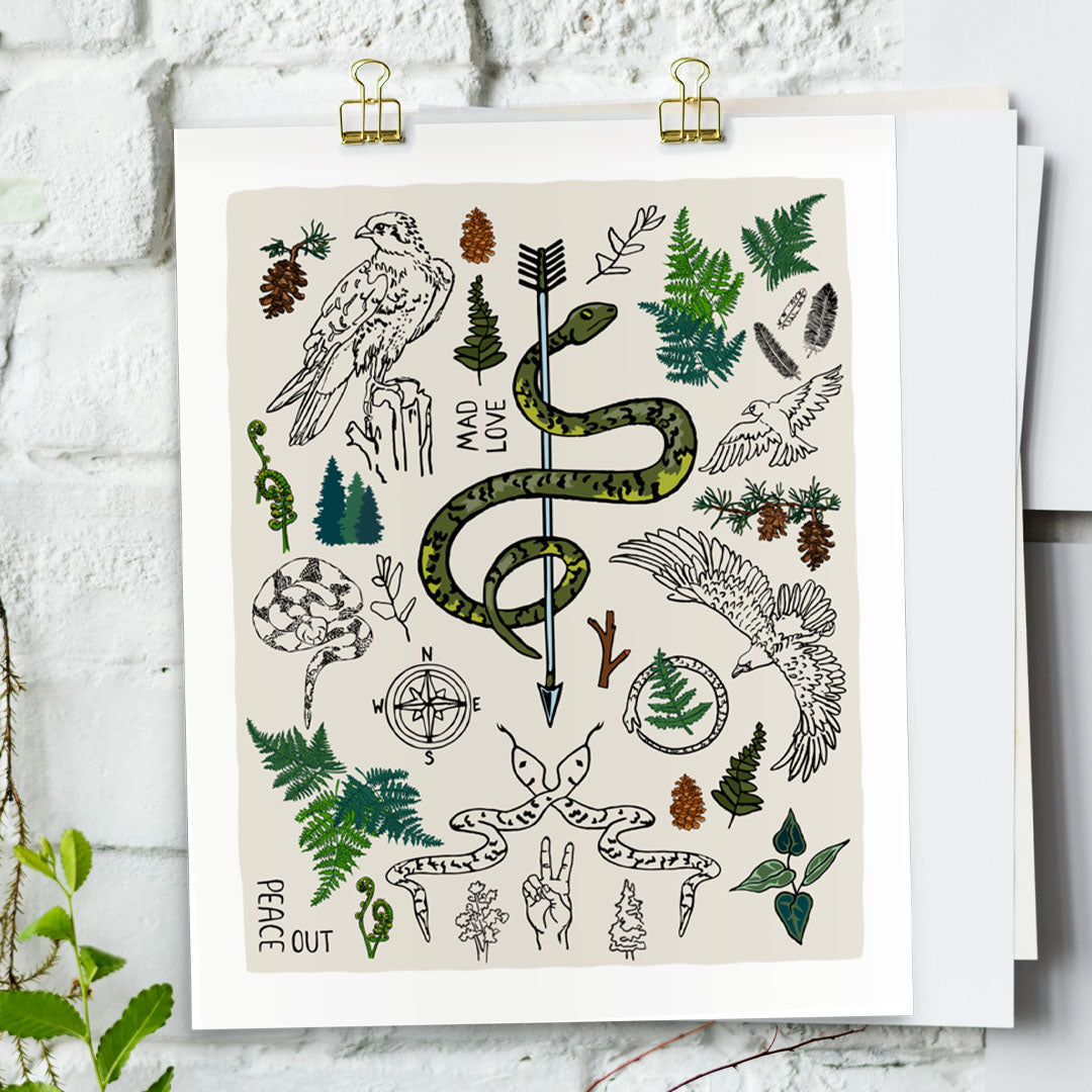 Peace Out in the Woods art print poster hung by gold clips on a white brick wall. The artwork has illustrations of eagles, snakes, ferns, a north star compass, pinecones, pine trees, an arrow, feathers, peace sign, and forest icons. 
