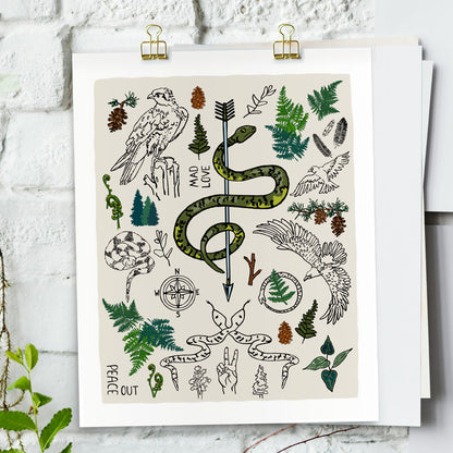 Peace Out in the Woods art print poster hung by gold clips on a white brick wall. The artwork has illustrations of eagles, snakes, ferns, a north star compass, pinecones, pine trees, an arrow, feathers, peace sign, and forest icons. 