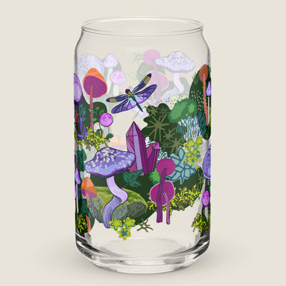 Purple Mushrooms glass tumbler on an ivory background. The artwork on the glass is a collection of purple and orange mushrooms, dragonflies, and various mosses nestled among wild ivy. The primary color palette is purples, vibrant oranges, and forest greens.