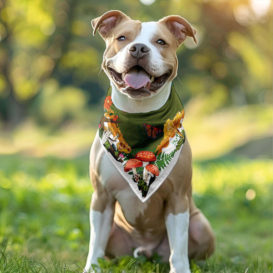 Happy dog wearing the red mushroom bandana around his neck.  He's sitting outside in the grass.