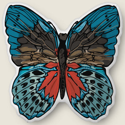 ​​A velvety, plush butterfly-shaped pillow in rich red and blue tones rests against an ivory background. Hand-drawn bohemian details and soft, sculpted texture make this cozy accent feel both artistic and nature-inspired.