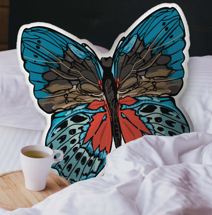 A velvety red and blue butterfly-shaped pillow nestled into a cozy, layered bed. The plush texture and hand-drawn bohemian details add a warm, nature-inspired touch to your space.