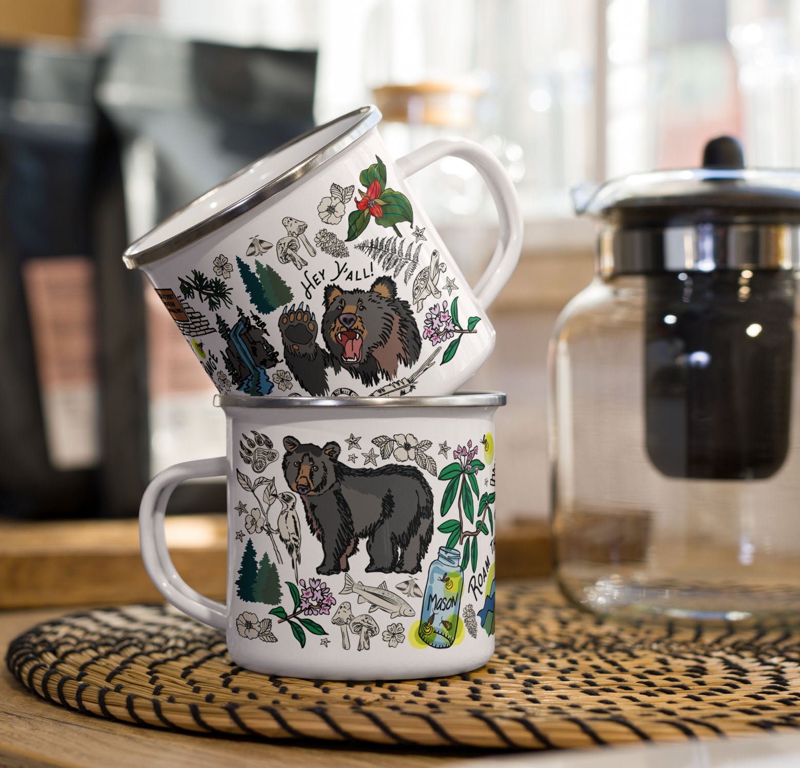 This is a photo of the enamel coffee mugs stacked on a kitchen counter sitting beside a coffee pot and bags of coffee.