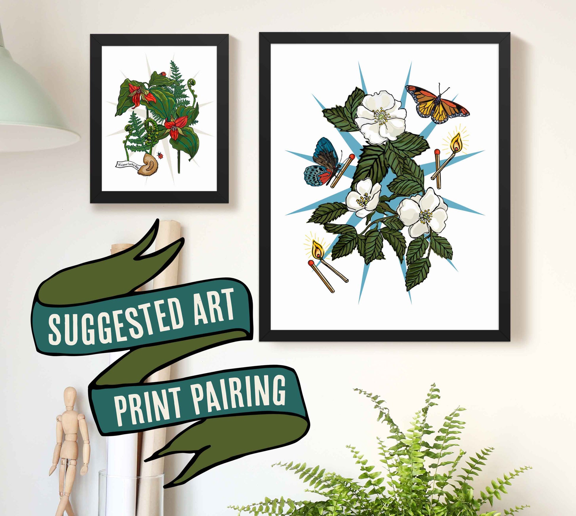 This is a photograph of two framed art prints from the Posh Pad Appalachian Rococo collection with a ribbon stating that this is a suggested art print pairing. The two prints in the photo are the Wild Roses & Butterflies paired with the Red Trillium & Good Fortune art print.