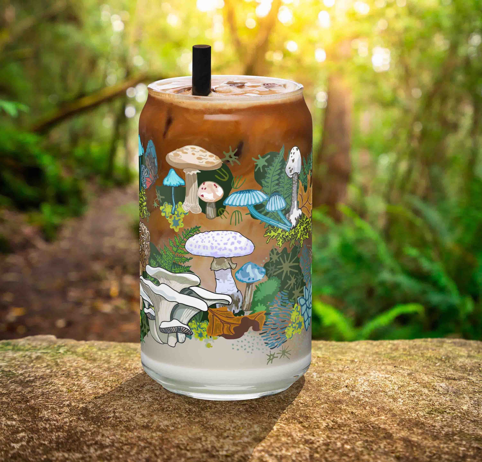 This is a photo of the glass containing an iced latte. It's sitting on a rock in the woods.