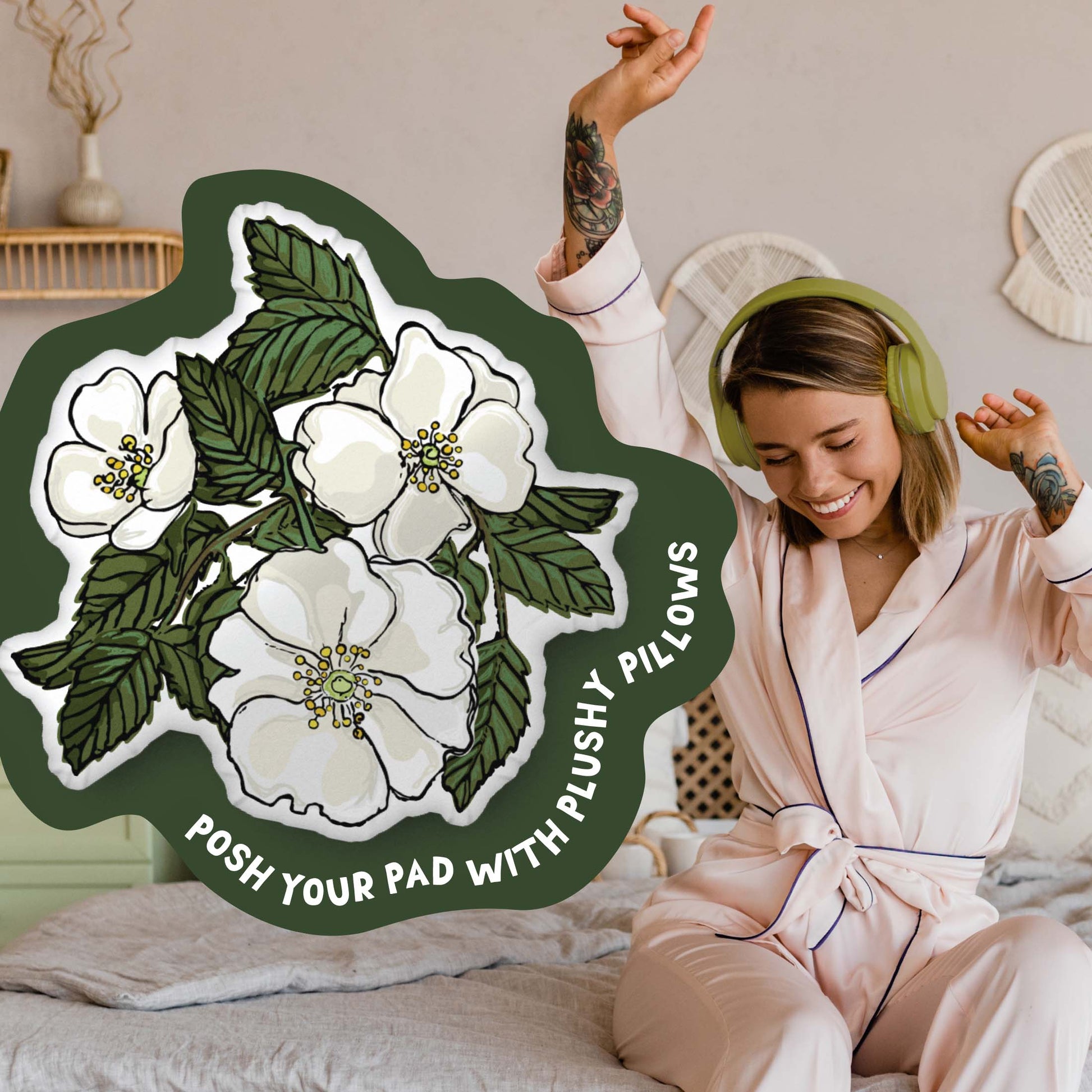 This image shows a photo of the rose-shaped pillow in a green organic shape. Inside the shape are the words "Posh your pad with plushy pillows". In the background, there is a photo of a woman in pajamas wearing headphones and sitting on a bed.