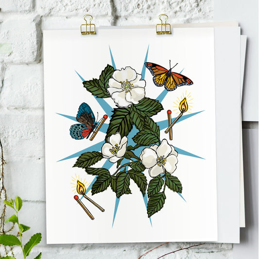 Wild Roses & Butterfly art print hanging from a white bring wall with gold clips.