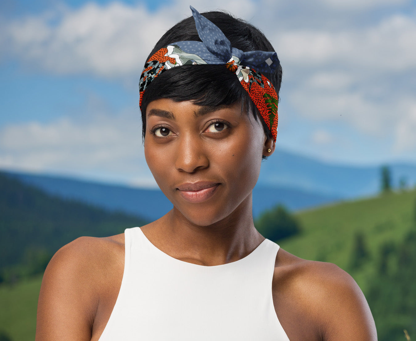 This is an image of a woman wearing the bandana as a headband. There is a mountain view behind her.